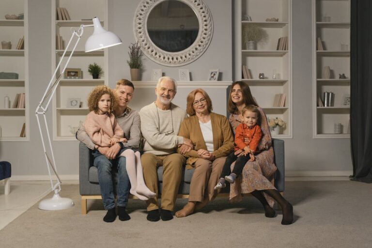 services-02 A multi-generational family sitting together on a sofa in a warm living room.