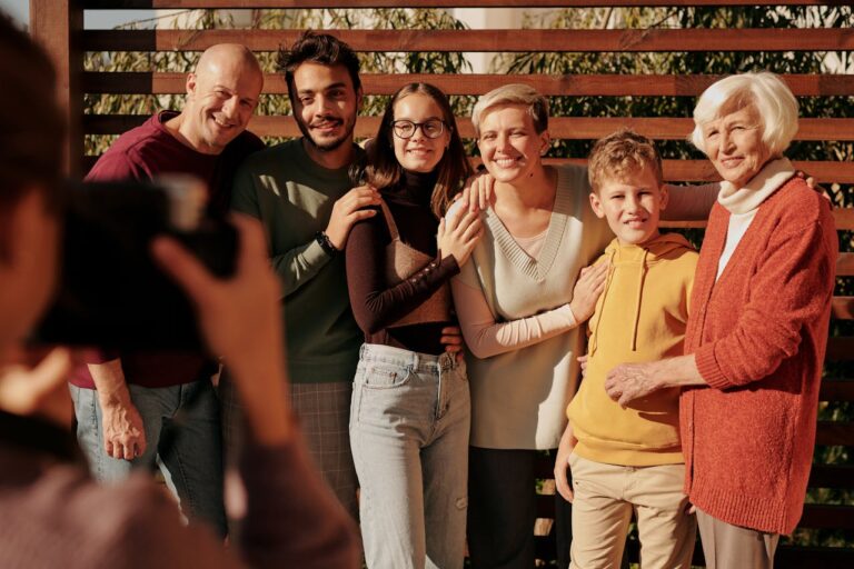 services-01 A joyful family portrait featuring multiple generations smiling outdoors in daylight.