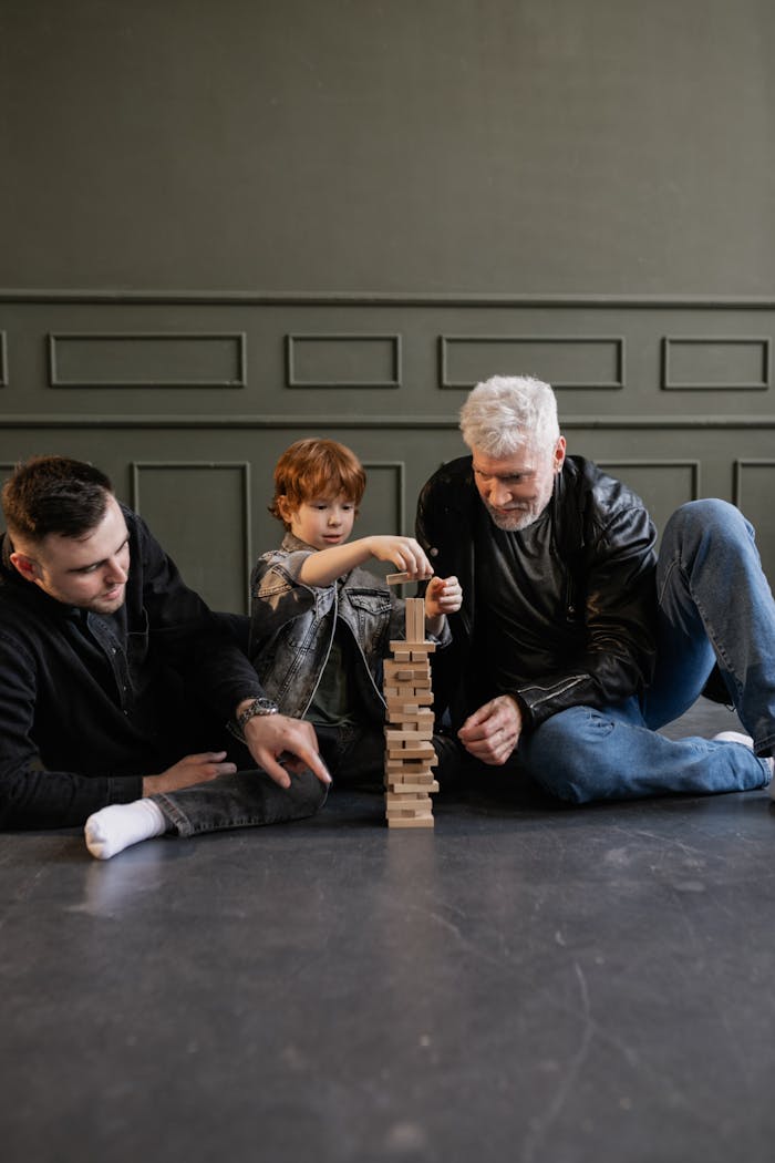 about-01 Three generations bonding over a game of Jenga indoors, highlighting family fun.
