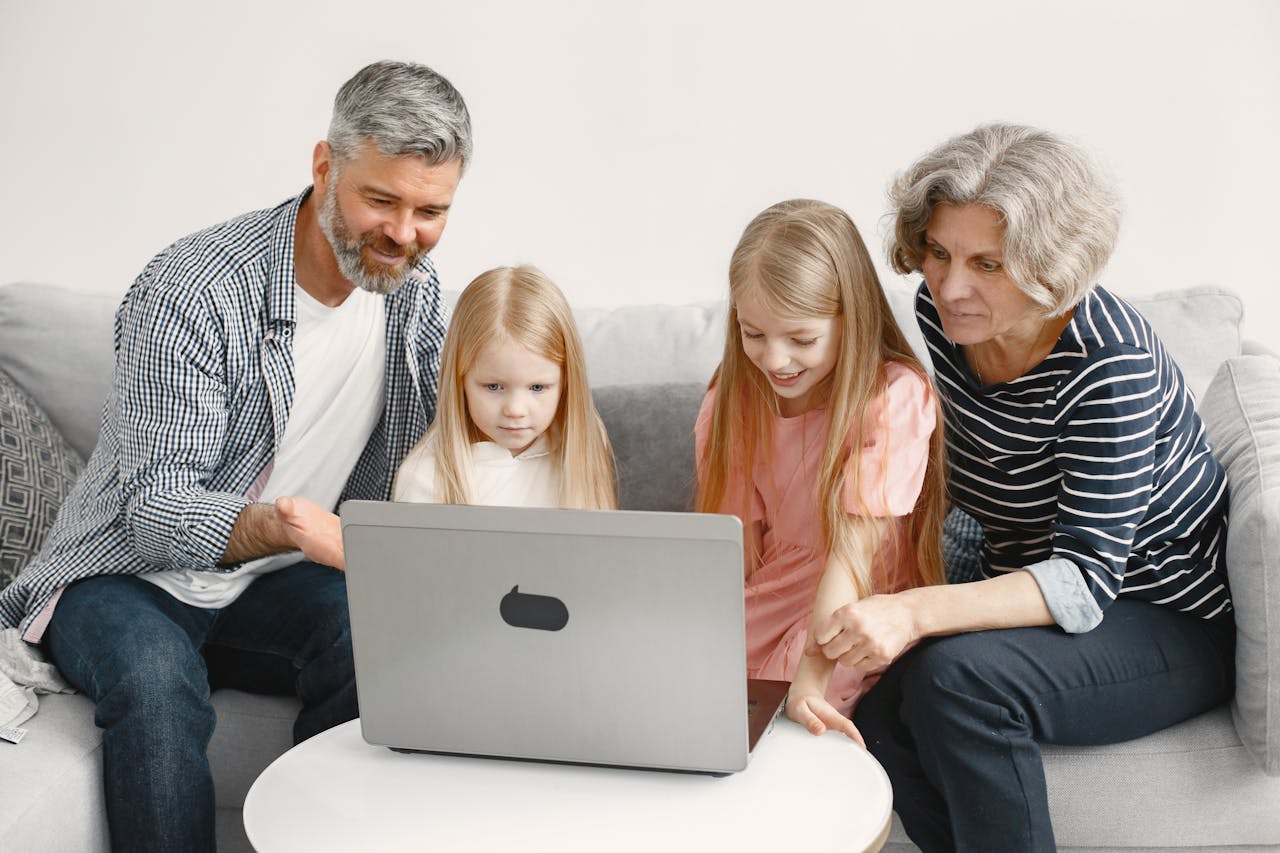 mission-02 Grandparents enjoying quality time with grandchildren using a laptop at home.